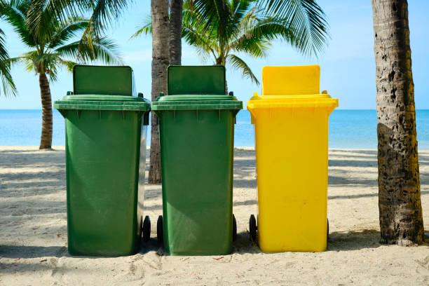 istock Green and yellow garbage containers installed on a tropical beach. Trash bins . Beach cleaning . 1293771833