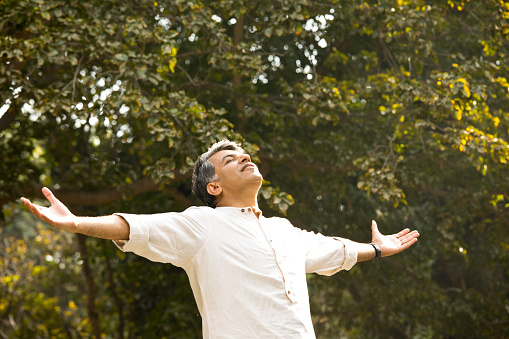 Happy man with arms outstretched at park