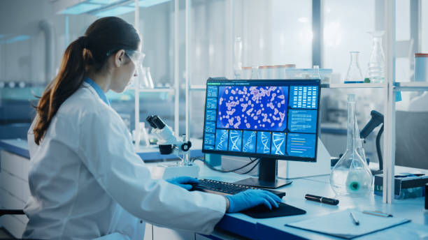 laboratorio di scienze mediche con diversi team multietnici di scienziati biotecnologici che sviluppano farmaci, microbiologo che lavora su computer con display che mostra l'interfaccia di editing genico. - research scientist healthcare and medicine discovery foto e immagini stock