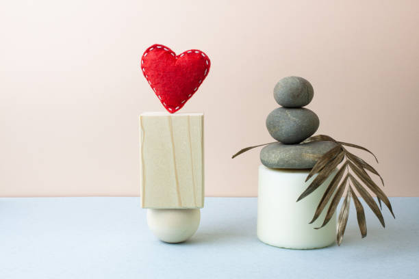 Abstract boho still life in pastel colors. Natural stone pyramid, wooden geometric shapes, palm leaf and heart.
