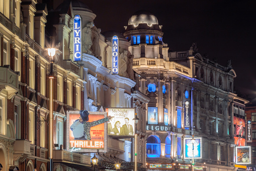The London West End theatre district comes alive at night with prominent theatres like the Lyric and the Apollo.