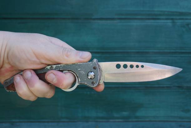 istock hand holds a gray steel hunting knife 1293786720