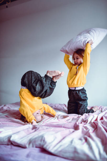 istock Female Children Having Pillow Fight In Bed 1293787623