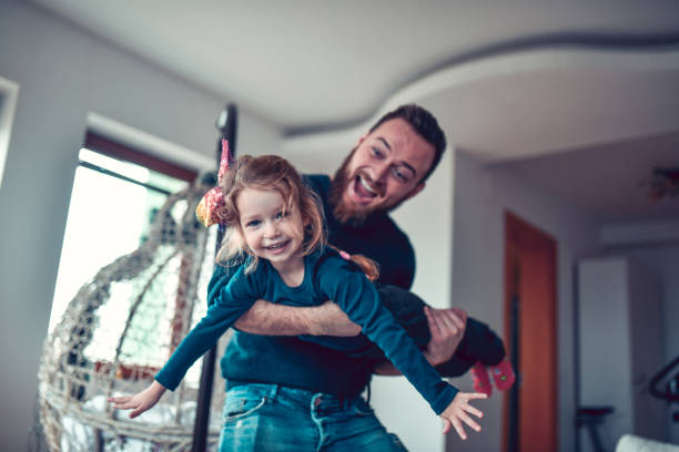 istock Father Lifting Kid Daughter And Playing With Her At Home 1293787684