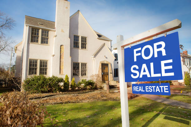 Classic Tudor Residential Home Real Estate For Sale A classic Tudor style house in the mid-west of United States for sale with sale sign on lawn. The two stories property with an old world facade, featuring a fire place chimney. houses for sale stock pictures, royalty-free photos & images