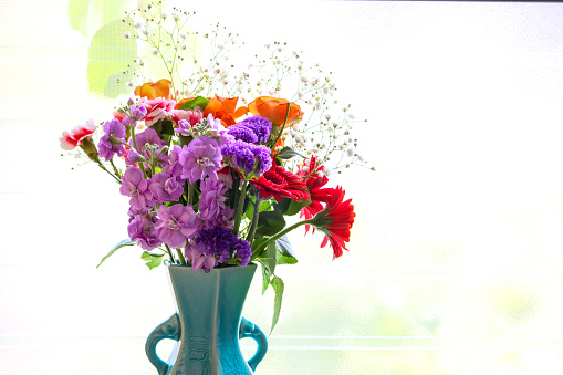 Pictured various kind of flowers in the blue vase.