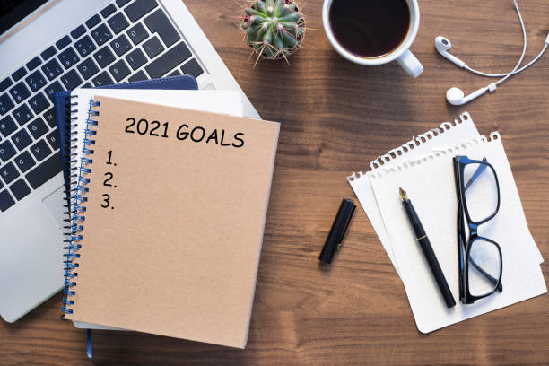 istock Note book with 2021 goals text on it to apply new year resolutions and plan. 1293795879
