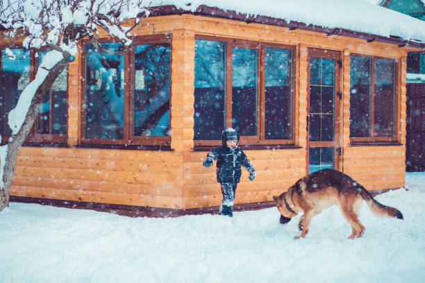 Little boy in the yard playing in the snow