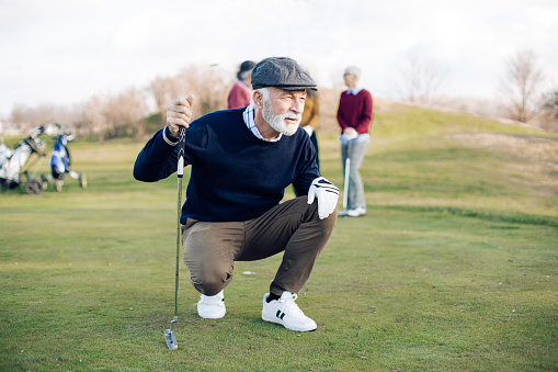 Senior man playing golf with his friends.