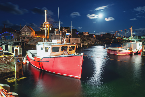 The full moon shines down on iconic Peggy's Cove. Long exposure.