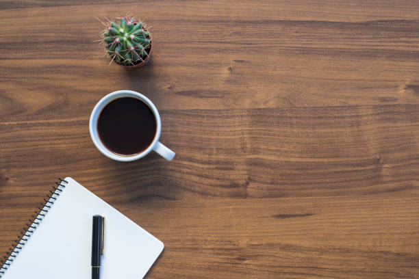 istock Workplace. Notebook and coffee cup on a wood office desk, copy space 1293800659