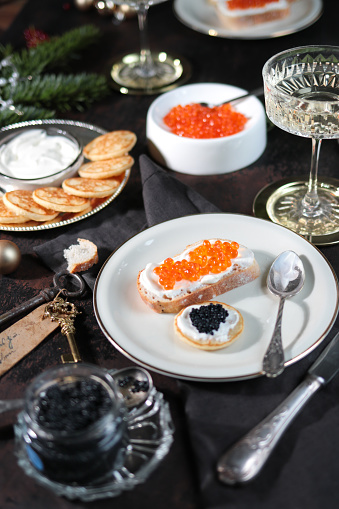 Festive Christmas Table with Caviar Blinis and Champagne in dark elegant table scene