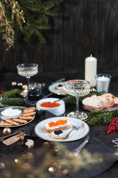 праздничный рождественский стол с икрой блинис и шампанским - appetizer caviar gourmet blini стоковые фото и изображения