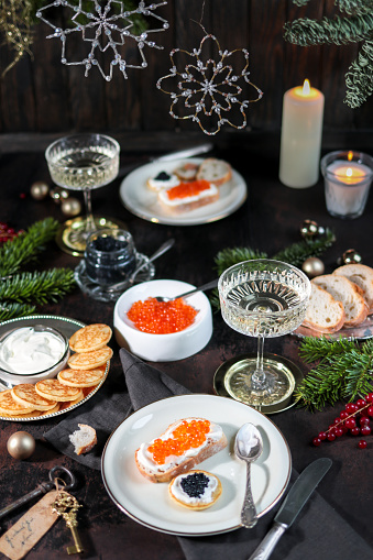 Festive Christmas Table with Caviar Blinis and Champagne in dark elegant table scene