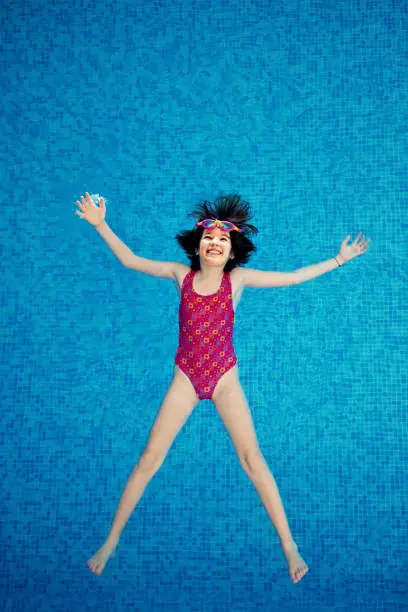 Photo of Portrait of little girl playing in a swimming pool