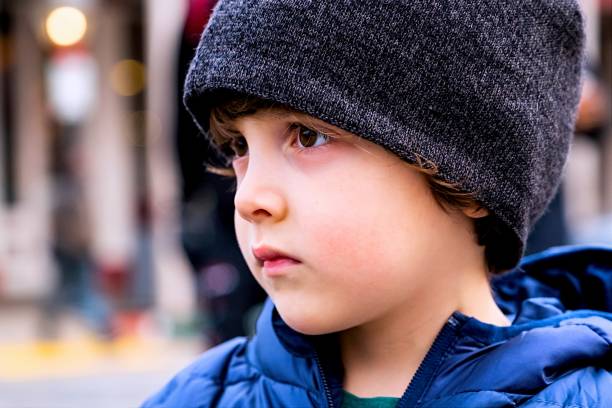 istock Serious pensive little boy looking away wearing a knit hat 1293802566