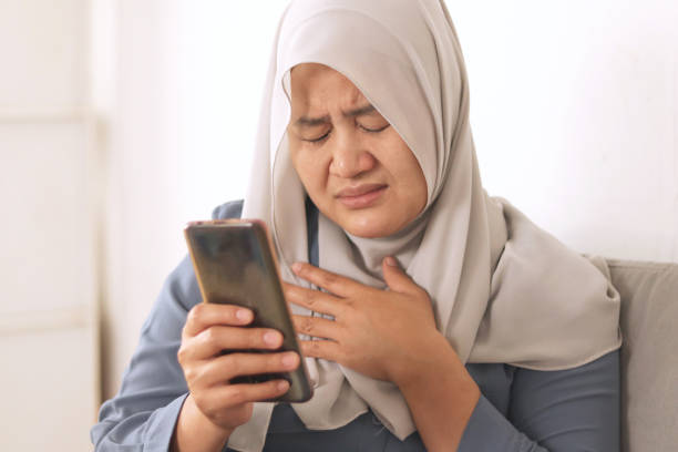 Sad, emotional Asian muslim woman crying and sends a message on mobile phone, bad news on phone Sad, emotional Asian muslim woman crying and sends a message on mobile phone, bad news on phone concept muslim divorce stock pictures, royalty-free photos & images