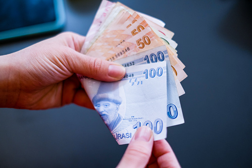 Mujer contando dinero en efectivo en fondos azules oscuros. Crédito en efectivo en moneda Lira turca. photo