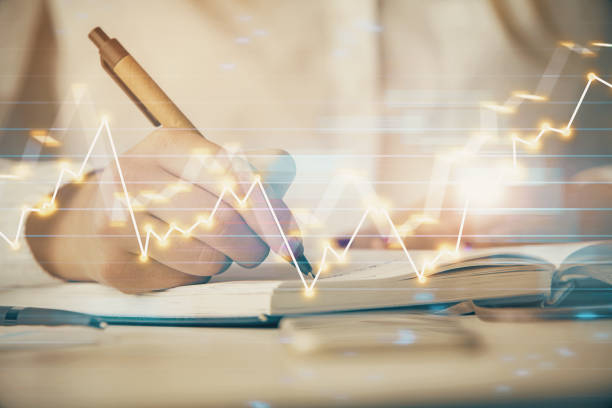 istock Multi exposure of woman's hands making notes with forex graph hologram. Concept stock market analysis. 1293808094