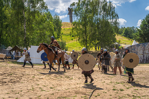 Cedynia, Poland, June 2019 Chieftain on horse and his warriors attacking fort with Czcibor Mountain in background. Historical reenactment of Battle of Cedynia between Poland and Germany, 11th century