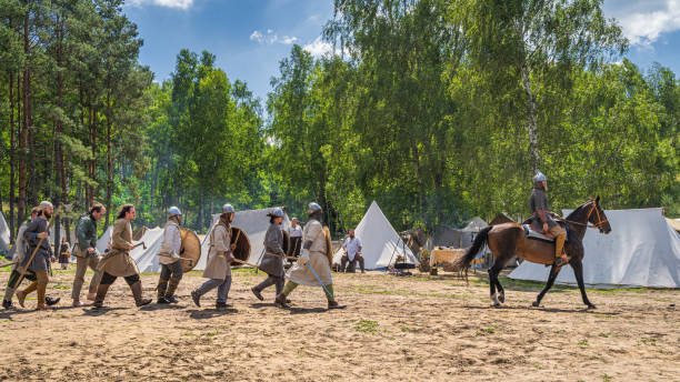 Cedynia, Poland, June 2019 Chieftain on the horse and his warriors passing tent camp. Historical reenactment of Battle of Cedynia between Poland and Germany, circa 11th century