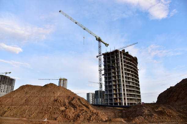 istock Tower crane in action at construction site on blue sky background 1293816198