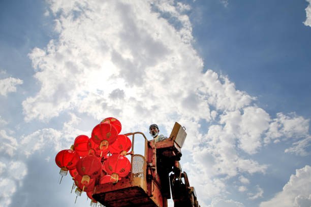 A Myanmar ethnicity worker on the crane is preparing to hang fresh red Chinese lantern in Thean Hou Temple - welcoming Chinese New Year in Kuala Lumpur, Malaysia.