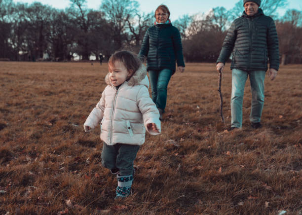 les grands-parents et la petite-fille marchent dans le parc - richmond park photos et images de collection