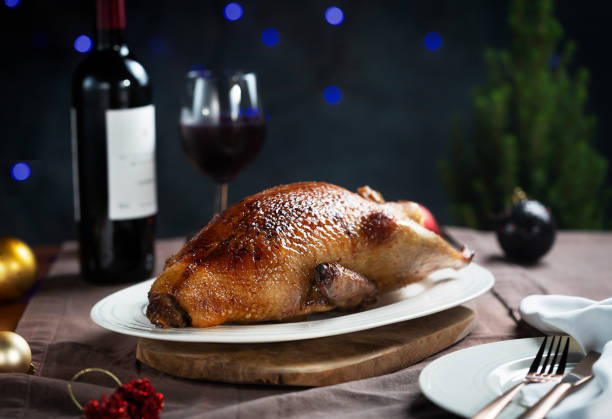 Crispy roasted Duck on a white plate ready for serving, dark and moody style photo