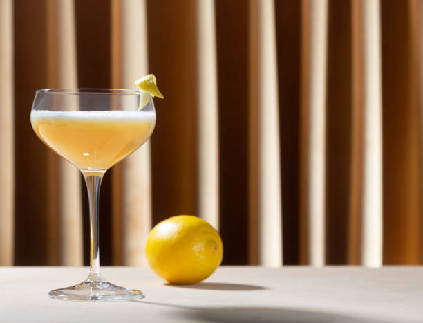 istock Glass filled with whiskey sour cocktail with lemon on the table 1293824616