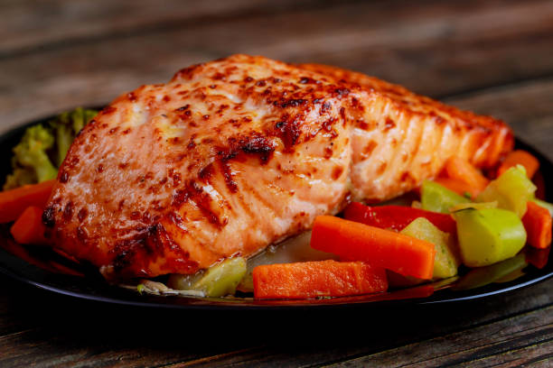 baked juicy salmon fillet with steamed vegetables on black plate. - pink salmon imagens e fotografias de stock