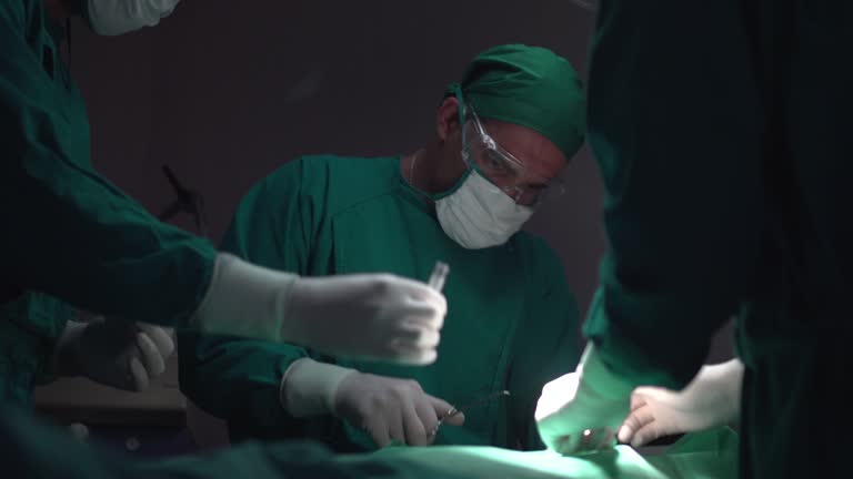 Doctors are surgery to patient’s body at operating room.