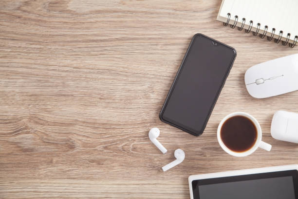 istock Coffee, smartphone, wireless earphones and other objects on the wooden table. 1293843524