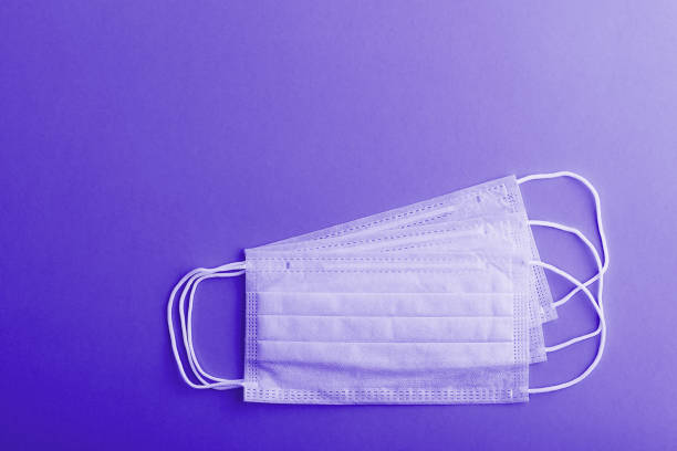 istock Medical mask protective virus, flu, disease. Isolated on a violet background. 1293848455