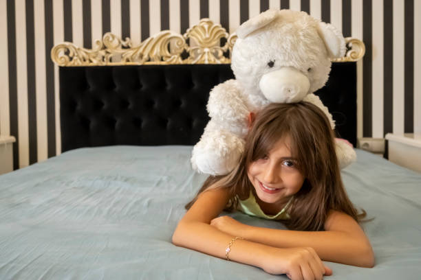 istock Cute girl happiness on bed with her teddy bear 1293862684