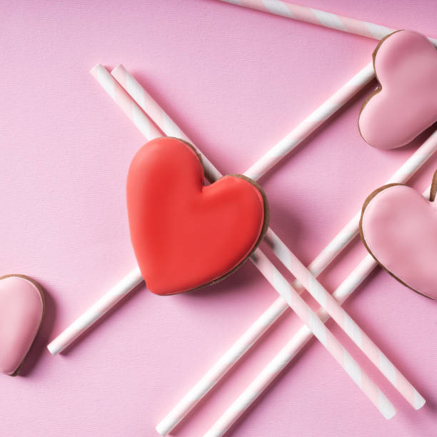 istock Glazed heart shaped cookies for Valentine's day on pink background 1293863394