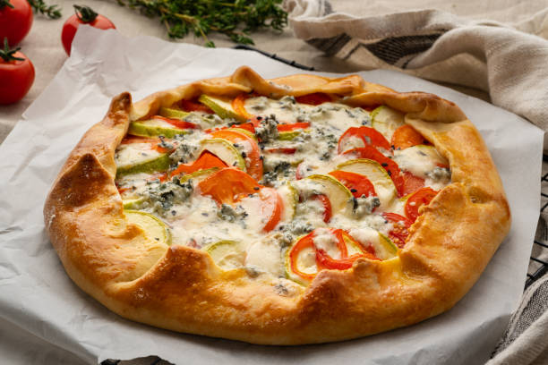 istock Homemade savory galette with vegetables, wheat pie with tomatoes, zucchini, side view 1293875296