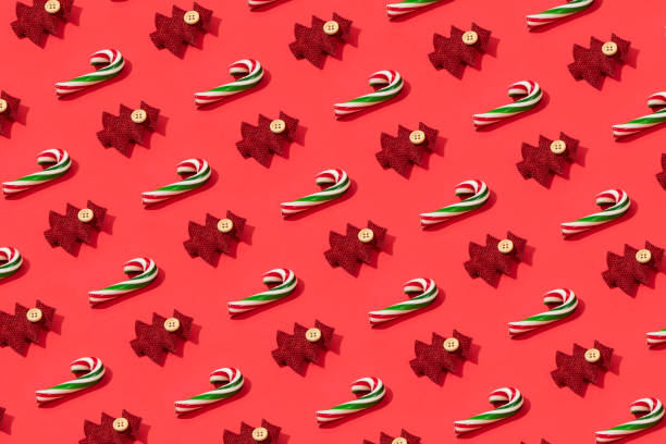 Christmas ornaments and candy canes in a row on red background