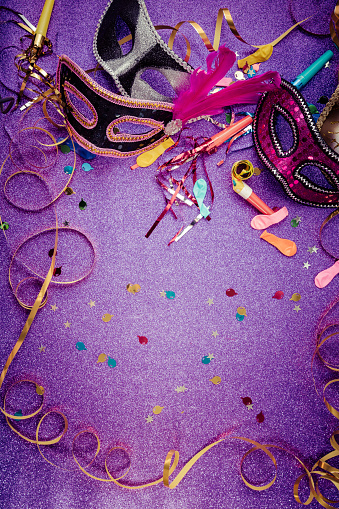 Carnival Mask, Streamers And Confetti For Festive Background in violet tone with copy space