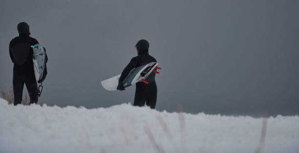 istock Arctic surfers running on beach after surfing 1293877876