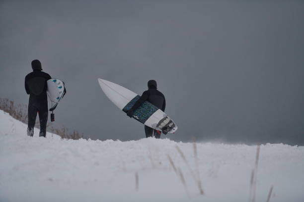 istock Arctic surfers running on beach after surfing 1293878068