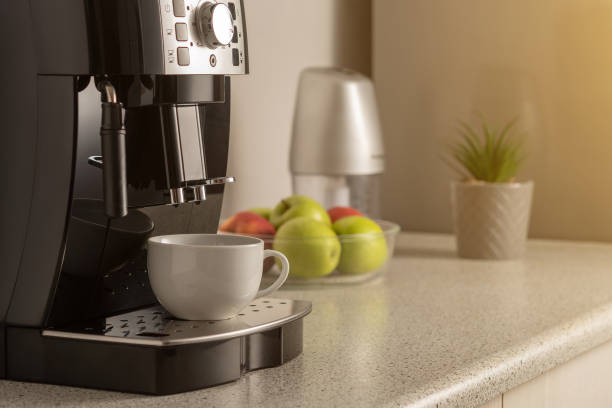 istock Modern espresso coffee machine with a cup in interior of kitchen closeup. 1293879143