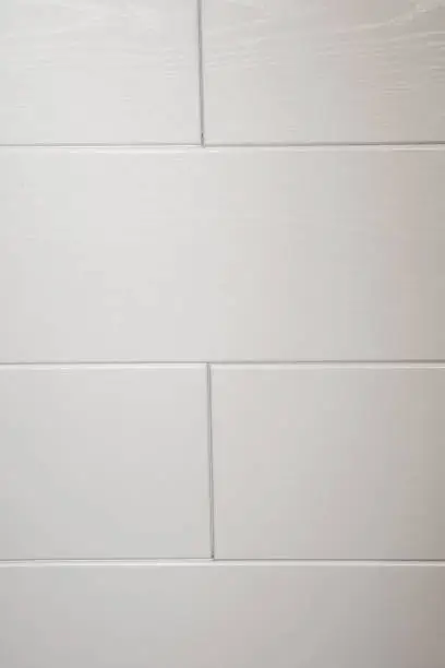 Photo of White tiles and gray joints on the wall