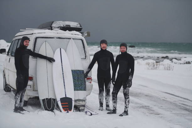 Arctic surfers in wetsuit after surfing by minivan