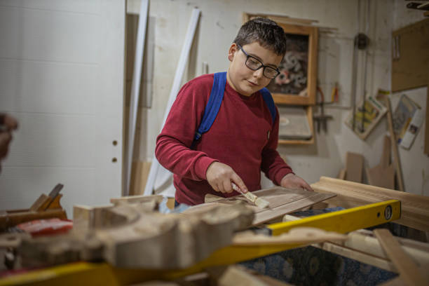 istock Teenage boy doing some crafts in carpentry workshop 1293883806
