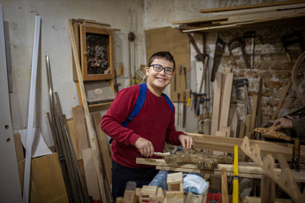 istock Teenage boy doing some crafts in carpentry workshop 1293883838