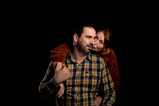 istock Middle-aged couple with attitude of love posing on a black studio background 1293886361