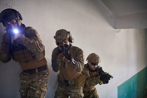 special forces squad team of us marines soldiers ascent stairs in tactical formation