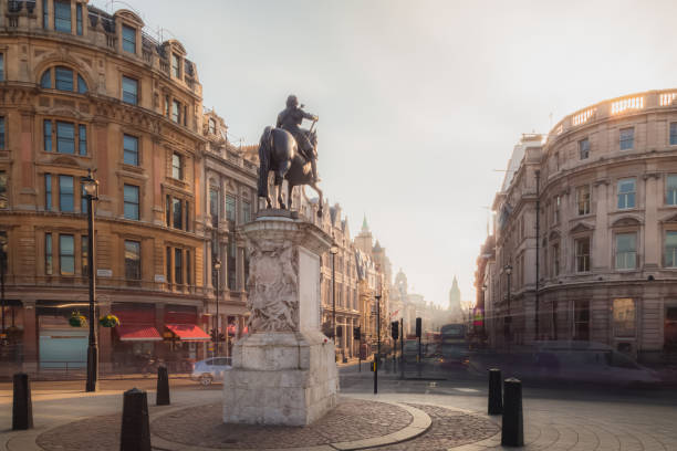 A view of the Equestrian Statue of Charles I from Trafalgar Square in Central London as golden light crests the building tops