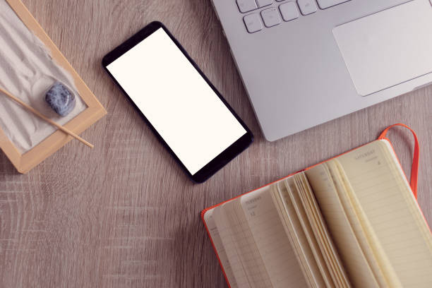istock Flat lay, top view of a office table desk. Workshop layout with smartphone, notebook, laptop, and a zen garden on wooden background. Copy space. 1293891097